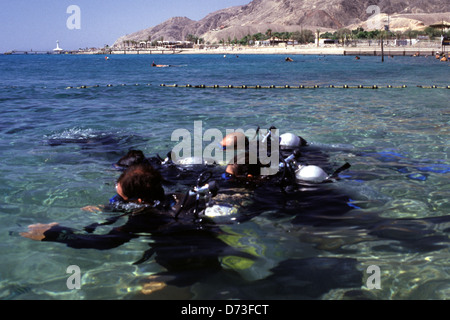 Les plongeurs stagiaires pratique dans les eaux peu profondes du Dolphin Reef d'Eilat dans le sud d'Israël Banque D'Images