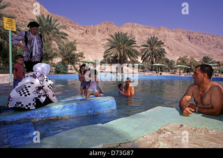 Une famille palestinienne se baigner dans une piscine d'eau à Ein Feshkha ou Einot Tzukim nature réserver son nom d'un printemps de l'eau saumâtre de la région sur la rive nord-ouest de la Mer Morte Israël Banque D'Images