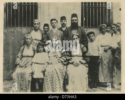 David Altchek (deuxième à partir de la droite, rangée arrière) pose avec la famille Kovo et le rabbin Emanuel Molho à Salonique (Thessalonique), en Grèce. La photographie, de la Fédération américaine des séfarades, documente la vie juive dans cette communauté. Banque D'Images