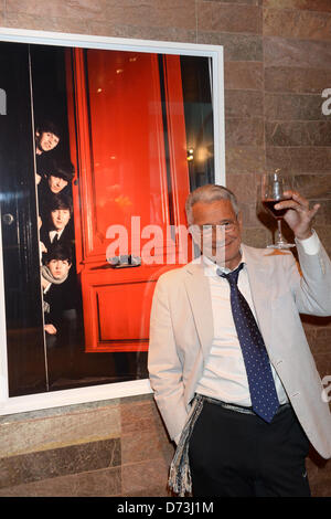 Photographe français Jean-Marie Perier soulève un verre qu'il pose en face d'une photographie intitulée 'les Beatles' à partir de 1964, lors du vernissage de l'exposition photo de "rampe" à Munich, Allemagne, 24 avril 2013. Photo : Felix Hoerhager Banque D'Images