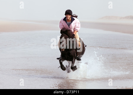 A cheval sur une plage de sable fin, Holkham beach Norfolk East Anglia, Angleterre Royaume-uni Banque D'Images