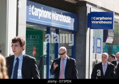 Magasin de vente au détail de téléphone portable d'entrepôt de Carphone Londres, avec manin au premier plan regardant le téléphone Banque D'Images