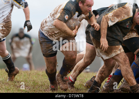 Les équipes s'affrontent en conditions boueuses pendant le tournoi de Rugby des cerisiers en fleur annuelle. Banque D'Images