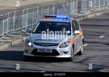 Voiture de police métropolitaine à grande vitesse avec feux d'avertissement clignotants bleus et deux hommes équipage Londres Angleterre Royaume-Uni Banque D'Images