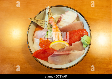 Bol de Chirashi Sushi avec sélection de tamago, le saumon, le thon, les oeufs de poisson, Saba, wasabi, le poulpe sur un lit de riz à sushi. Banque D'Images