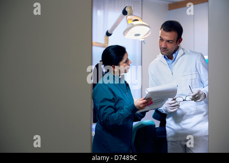 Dentiste parlant avec assistante en studio et à la recherche à des fichiers. Copy space Banque D'Images