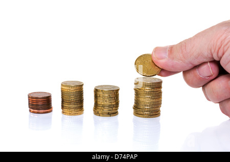 Man putting euro coin sur l'argent de la pile Banque D'Images