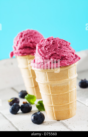 Deux glaces gaufres aux bleuets sur bois blanc avec fond bleu Banque D'Images