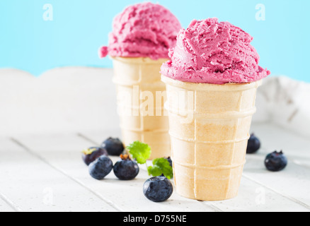 Deux glaces gaufres aux bleuets Les bleuets de côté sur bois blanc avec fond bleu Banque D'Images