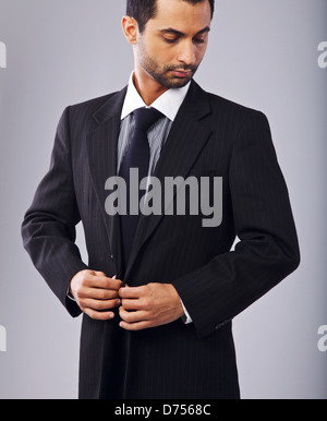 Portrait d'un homme élégant à boutonner son habit Banque D'Images