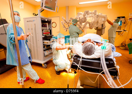 Prostatectomie radicale effectuée par robot da Vinci de la téléchirurgie, dont quatre bras articulés sont contrôlés par l'appareil photo à distance chirurgien Banque D'Images