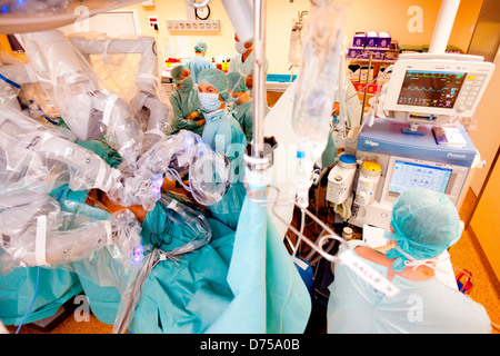 Prostatectomie radicale effectuée par robot da Vinci de la téléchirurgie, dont quatre bras articulés sont contrôlés par l'appareil photo à distance chirurgien Banque D'Images