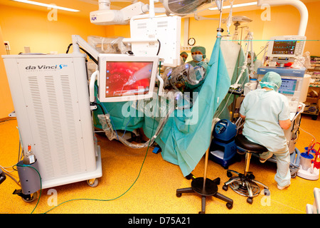 Prostatectomie radicale effectuée par robot da Vinci de la téléchirurgie, dont quatre bras articulés sont contrôlés par l'appareil photo à distance chirurgien Banque D'Images