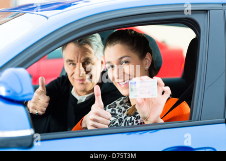 Auto-école - Jeune femme diriger une voiture, peut-être qu'elle a un examen de conduite Banque D'Images