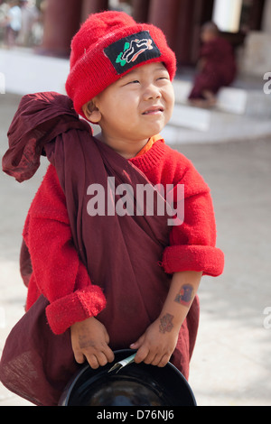 Petit garçon dans la robe de moine et red hat avec sa collection bol 5 Banque D'Images