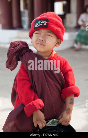 Petit garçon dans la robe de moine et red hat avec sa collection bol 3 Banque D'Images