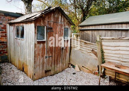 Vieux mal entretenue de fonctionner vers le bas du panneau de toile abri de jardin en bois avec toit endommagé et le trou à partir de la pourriture du bois Banque D'Images