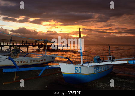 Indonésie Bali Lovina dans la région du Nord, des bateaux de pêche sur la plage au crépuscule Banque D'Images