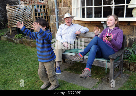 Grand-père et ses petits-enfants célébrant le grand-père temps rapide dans un jardin concours obstacle Banque D'Images