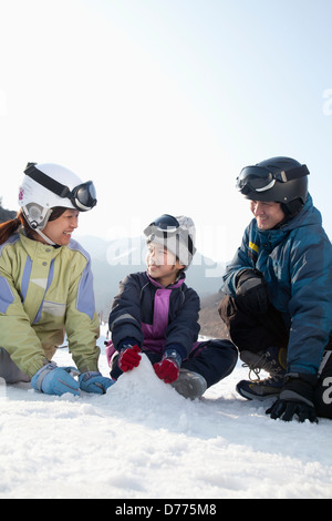 Famille jouer dans la neige Banque D'Images