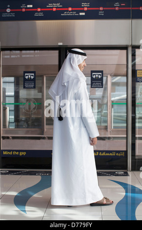 L'homme arabe en costume traditionnel à la station de métro à Dubaï Banque D'Images