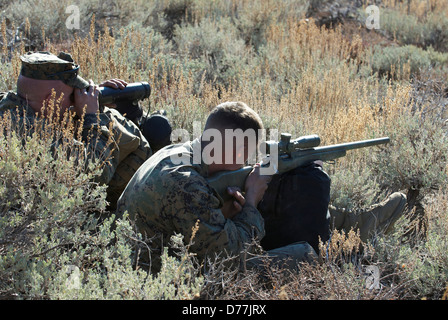 L'aide de l'US Marine Marine en utilisant un autre télescope visant M40A3 Sniper Rifle cible pendant l'angle de la formation de haute montagne sniper Banque D'Images