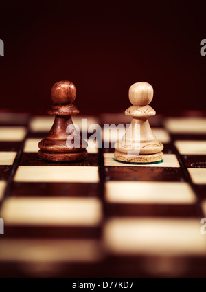 Deux pions d'échecs sur un échiquier, concept Banque D'Images