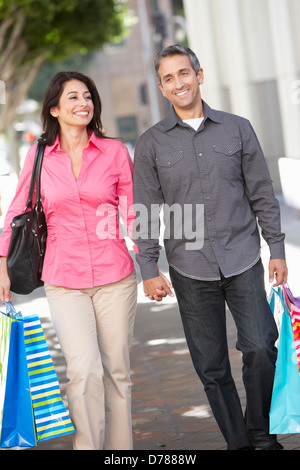 Couple Carrying Shopping Bags On City Street Banque D'Images