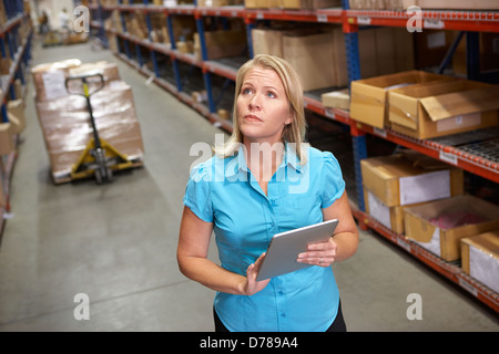 Businesswoman Using Digital Tablet In Distribution Warehouse Banque D'Images