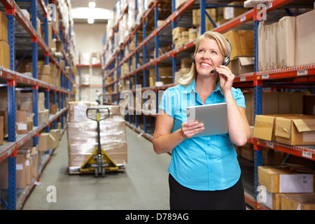 Businesswoman Using Digital Tablet In Distribution Warehouse Banque D'Images