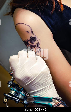 Le processus de faire un tatouage sur l'épaule de la jeune fille Banque D'Images