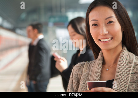 Jeune femme attendant sur plate-forme du train avec le café Banque D'Images