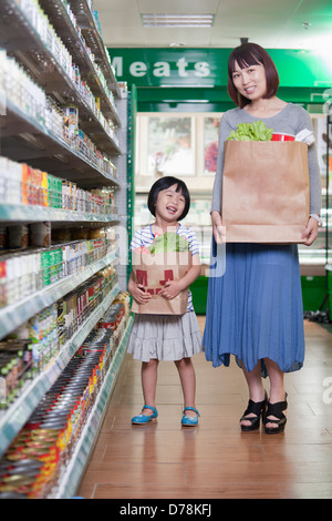 Mother and Daughter holding sacs en supermarché, Beijing Banque D'Images