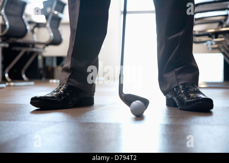 Businessman jouer au golf dans son bureau, Close up sur pieds Banque D'Images