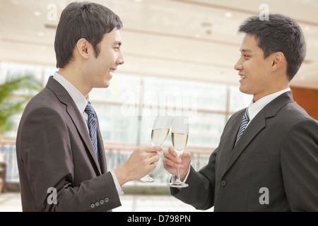 Deux hommes d'Toasting Champagne Flutes Banque D'Images