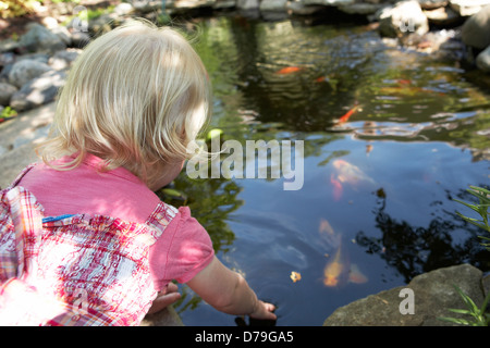 2 year old girl playing in garden. Banque D'Images