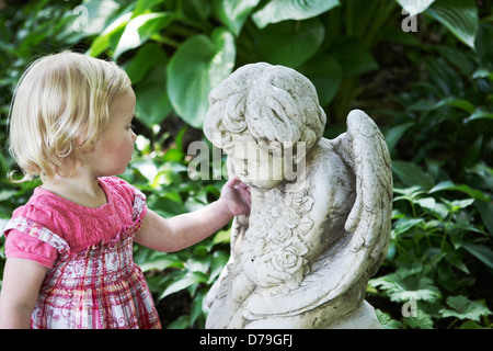 2 year old girl playing in garden. Banque D'Images