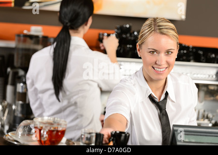 Young waitress cashier giving coffee in cafe Banque D'Images