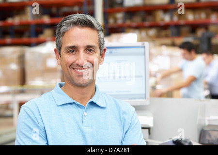 L'homme à l'ordinateur dans l'entrepôt de distribution Banque D'Images