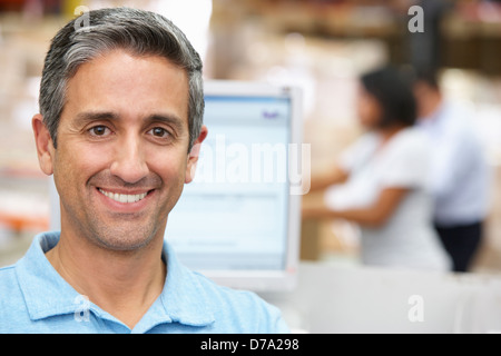 L'homme à l'ordinateur dans l'entrepôt de distribution Banque D'Images