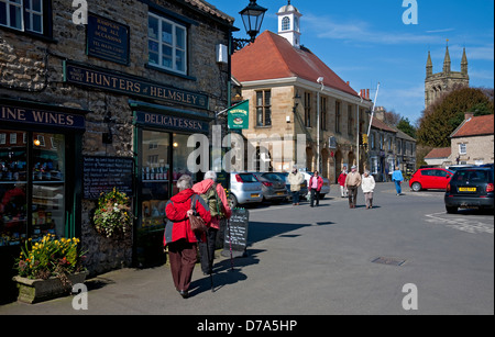 Personnes touristes visiteurs marchant près des magasins dans le marché de printemps Helmsley centre-ville North Yorkshire Angleterre Royaume-Uni Grande-Bretagne Banque D'Images