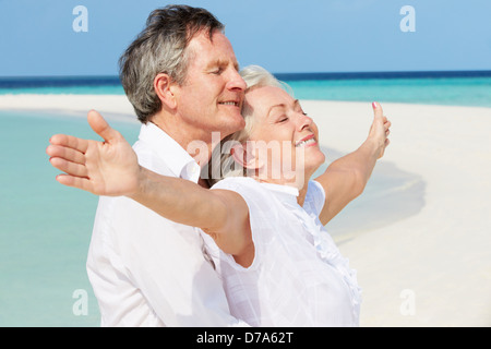 Senior Couple Withs bras tendus sur la belle plage Banque D'Images