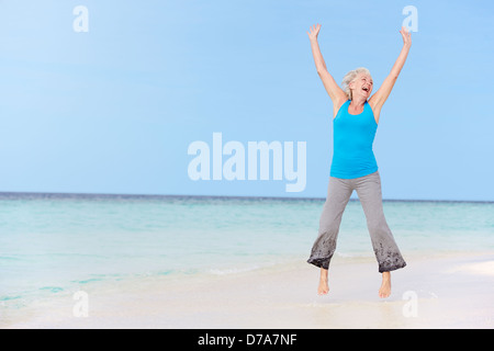 Senior Woman Jumping on Belle Plage Banque D'Images