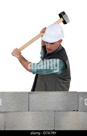 Mason smashing wall Banque D'Images