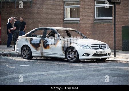 Salon de voiture blanc brûlé après émeute incendie criminel Banque D'Images
