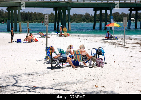 Famille profiter de la chaleur des rayons du soleil de printemps sur Coquina Beach Florida Banque D'Images