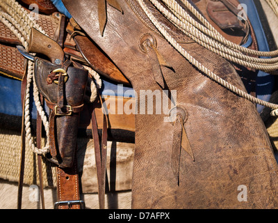 Texas Travail avec selle cowboy chaps et lariat pistolet. Banque D'Images