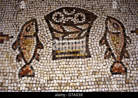 Mosaic représente deux poissons flanquant un panier contenant quatre miches de pain.sur le sol de l'église de la multiplication des pains et des poissons dans une aire située sur Tabgha la rive nord-ouest de la mer de Galilée en Israël Banque D'Images