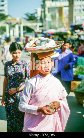 Jeune religieuse bouddhiste en robe rose dans une rue animée de Mandalay, Birmanie (Myanmar) Banque D'Images