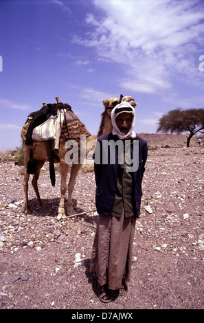 Nomades bédouins membre de la tribu Zawaideh, originaire de les déserts du sud de la Jordanie et de l'ouest de l'Arabie saoudite avec son chameau dans le désert de Wadi Rum connu aussi sous le nom de la vallée de la lune, dans le sud de la Jordanie Banque D'Images